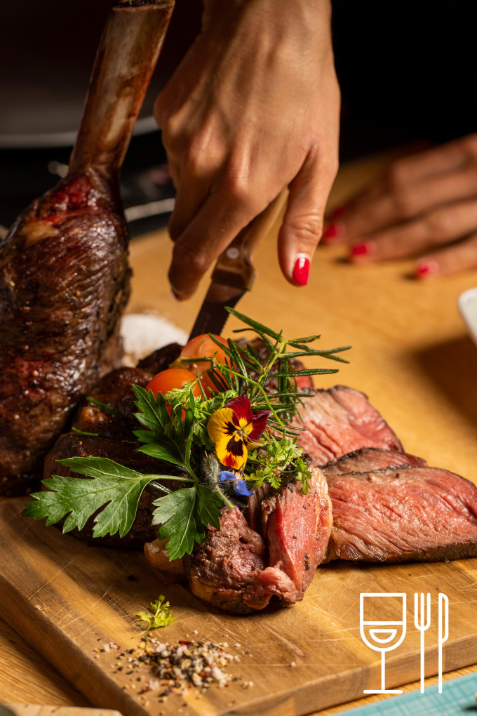 eine Person, die Fleisch mit einem Messer schneidet