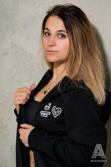 Black zipper jacket with hood. Hannes Alm and Susi Alm logo on the front left.