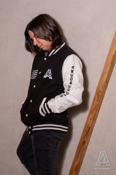 Black and white college jacket: Alpenwelt logo on the front left, Bergliebe.Rocks lettering on the left sleeve